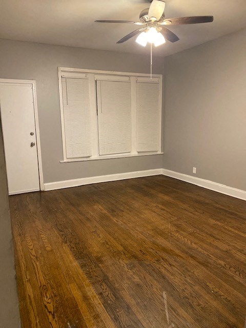 an empty room with a ceiling fan and a door