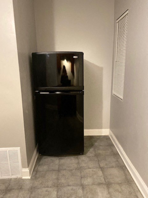 a black refrigerator in a corner in a room