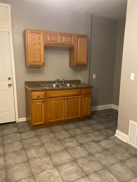 a bathroom with a sink and wooden cabinets
