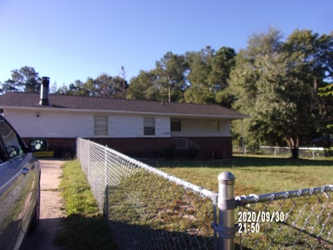 a house with a fence and a car parked in front of it