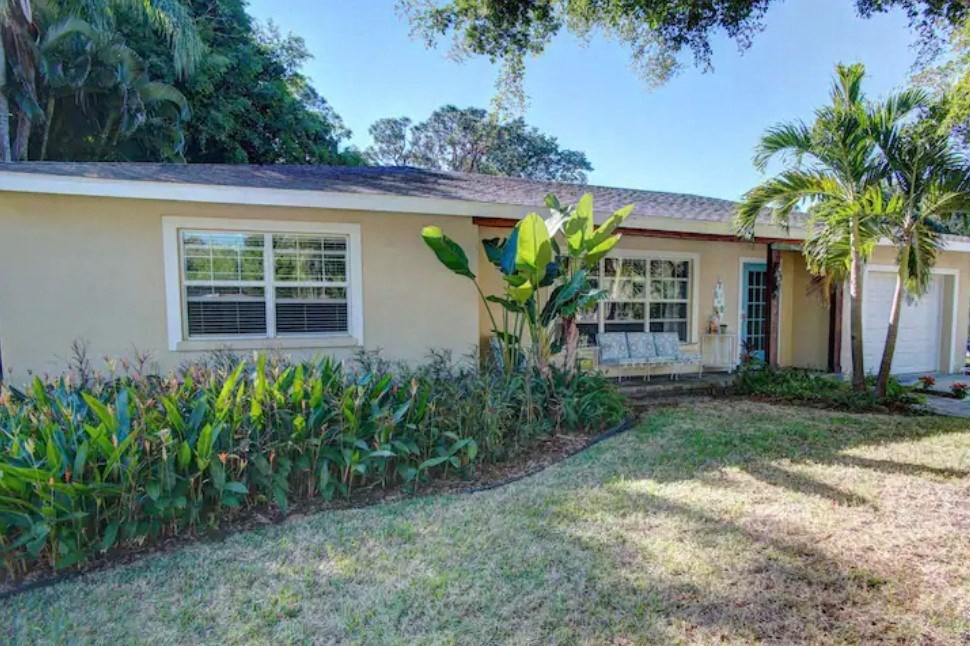 a house with a yard and a palm tree in front of it