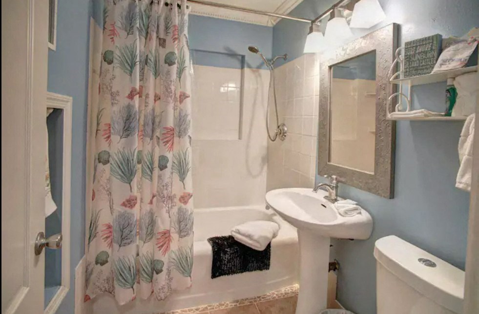 a bathroom with a shower curtain and a sink and a toilet