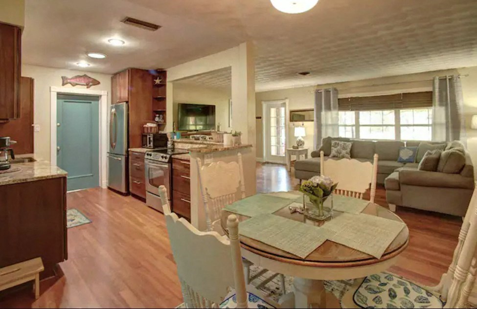a kitchen and living room with a table and chairs