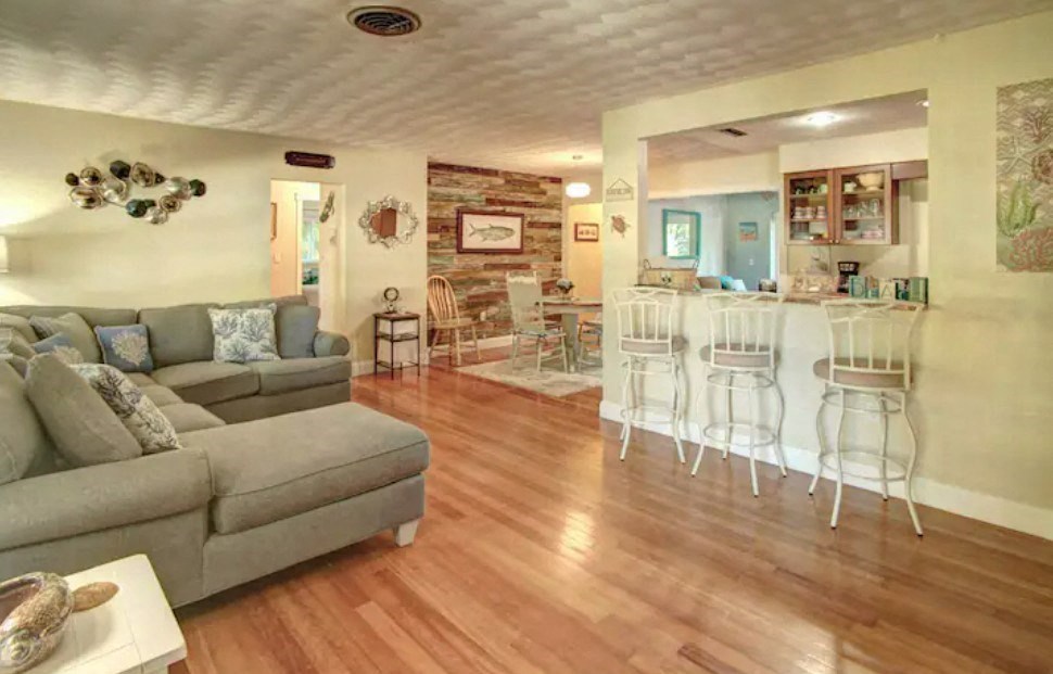 a living room with a couch and a kitchen with a bar