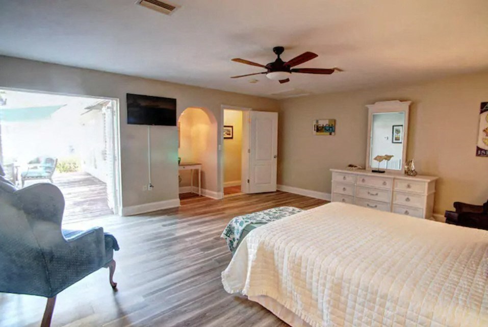 a large bedroom with a large bed and a ceiling fan