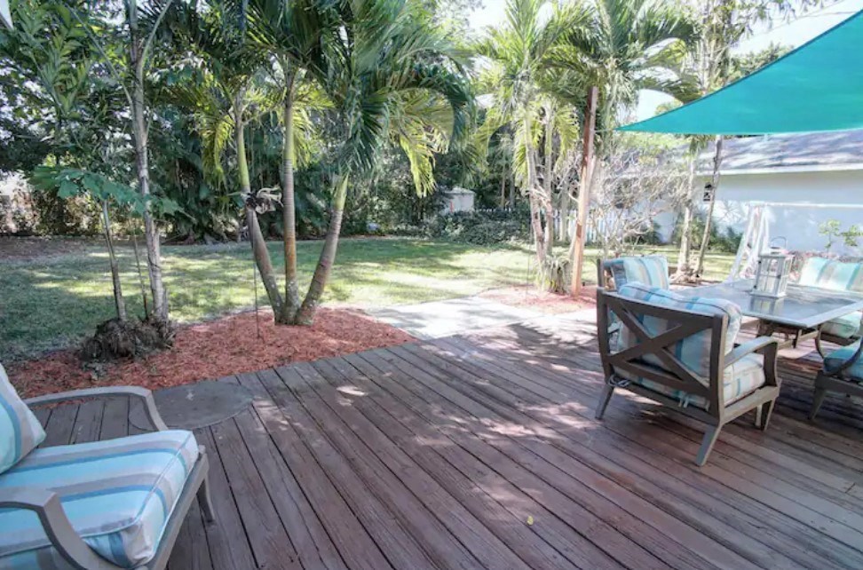 a patio with a table and chairs on a wooden deck