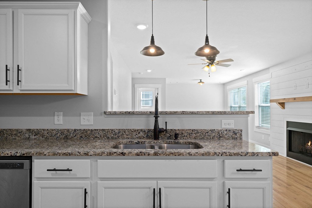 a kitchen with white cabinets and a granite counter top