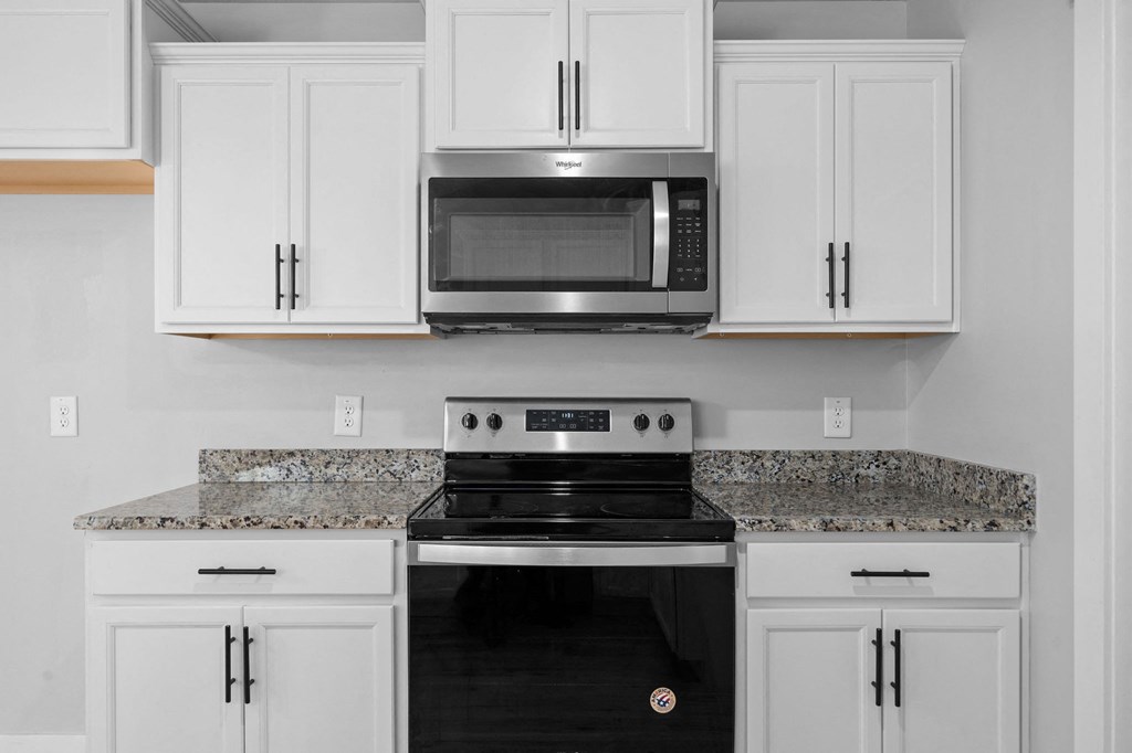 a kitchen with white cabinets and a black stove