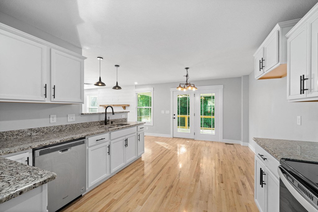 a kitchen with white cabinets and a hard wood floor