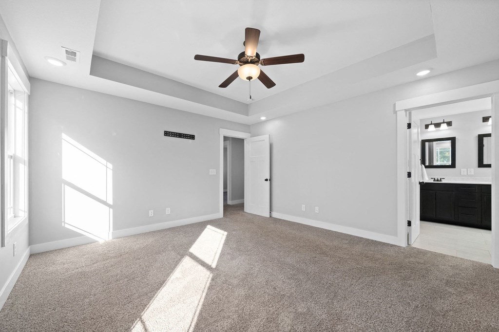 a living room with white walls and a ceiling fan