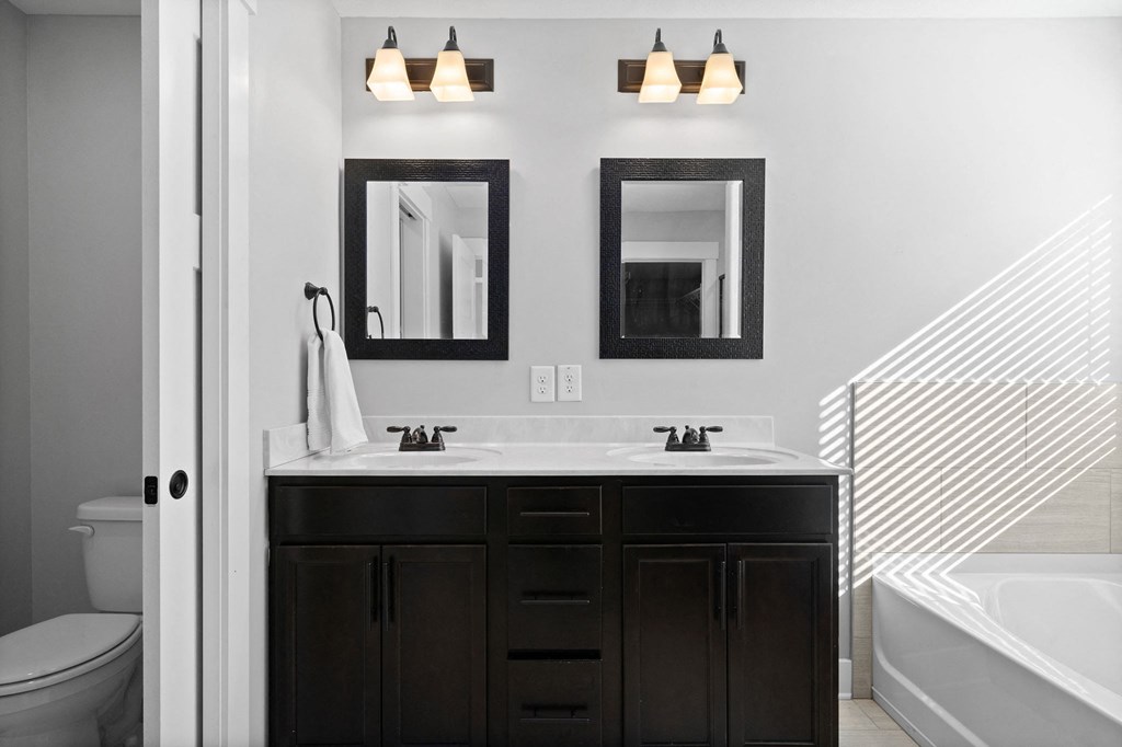 a bathroom with a sink and two mirrors