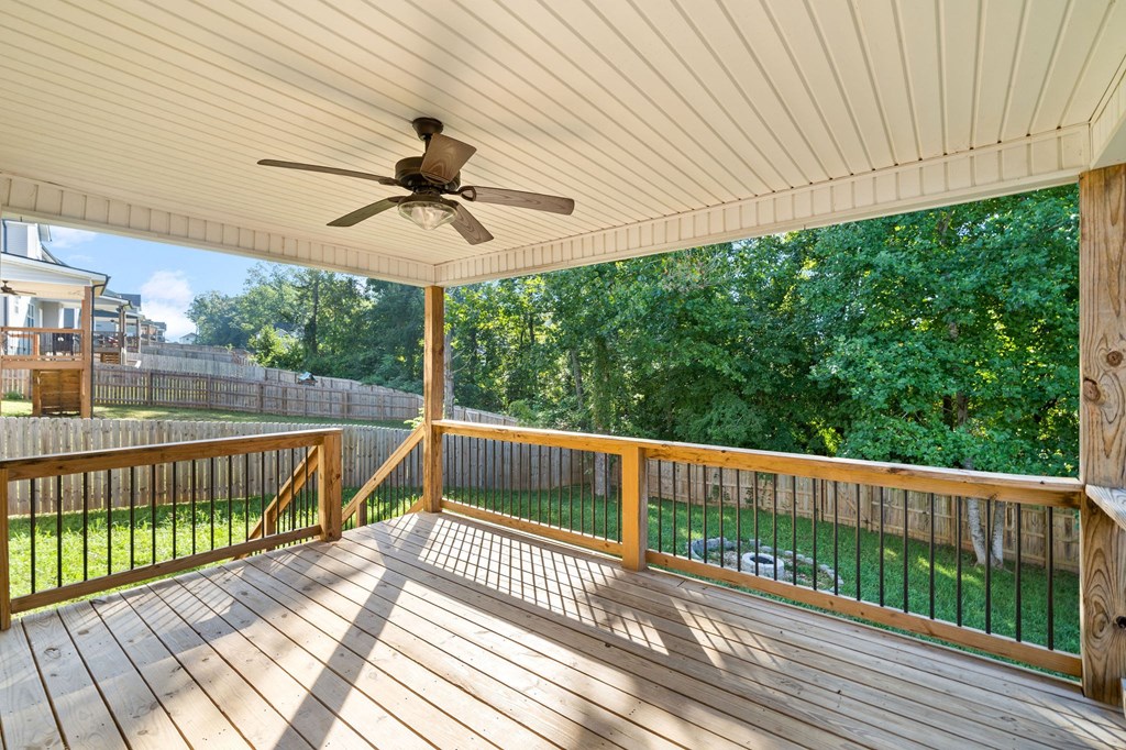 a covered porch with a ceiling fan and a view of a yard