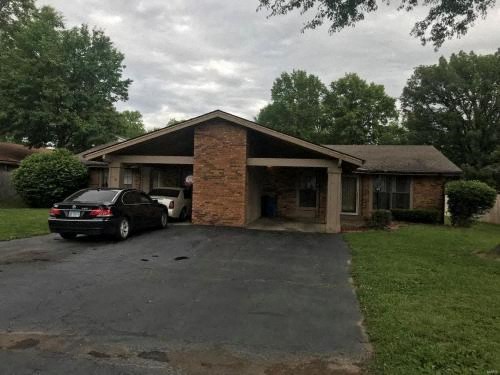 A black car is parked in front of a house.