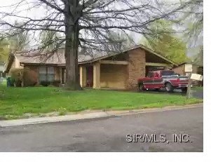 A house with a red car parked in front.