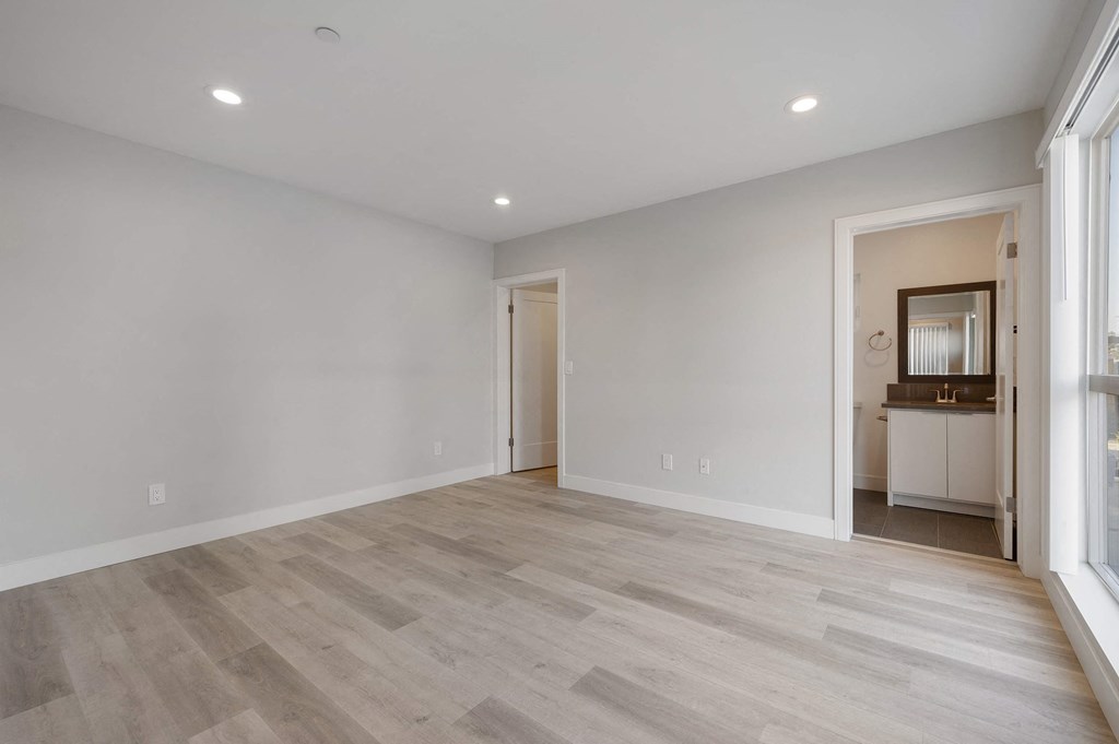 a living room with white walls and wood floors