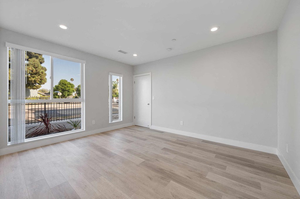 a living room with a large window and wooden floors