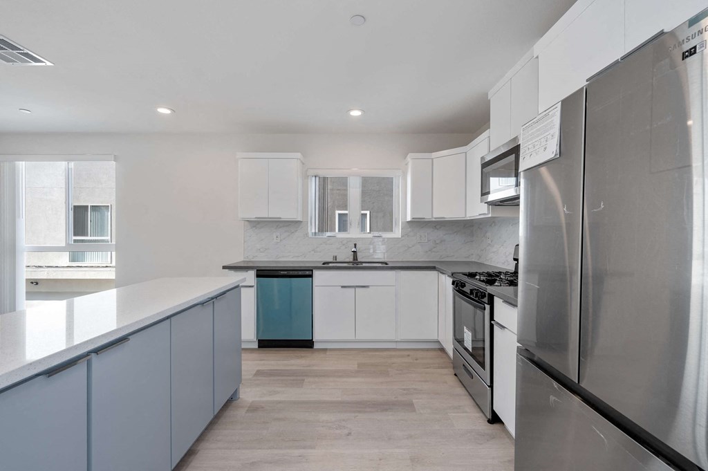 a kitchen with stainless steel appliances and white cabinets