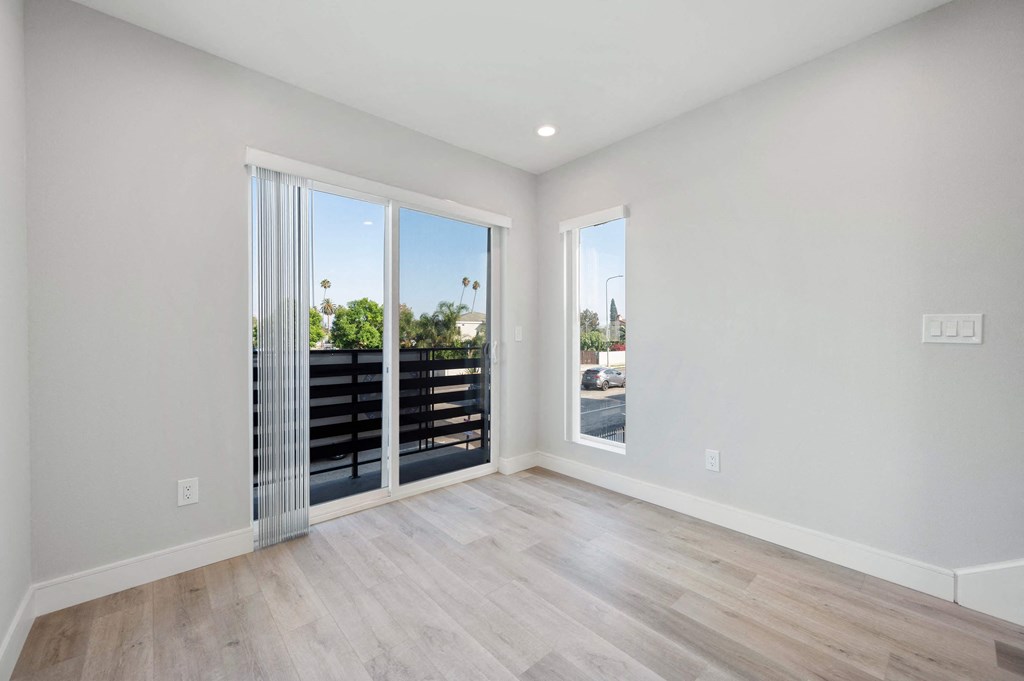 a spacious living room with sliding glass doors to a balcony