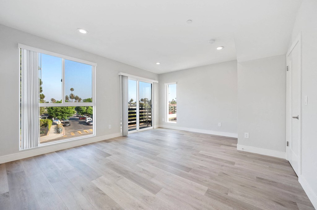 a living room with a large window and a wooden floor