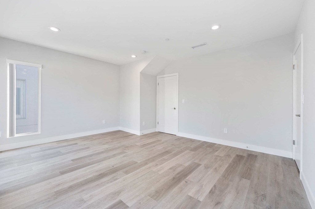 a living room with white walls and wood floors