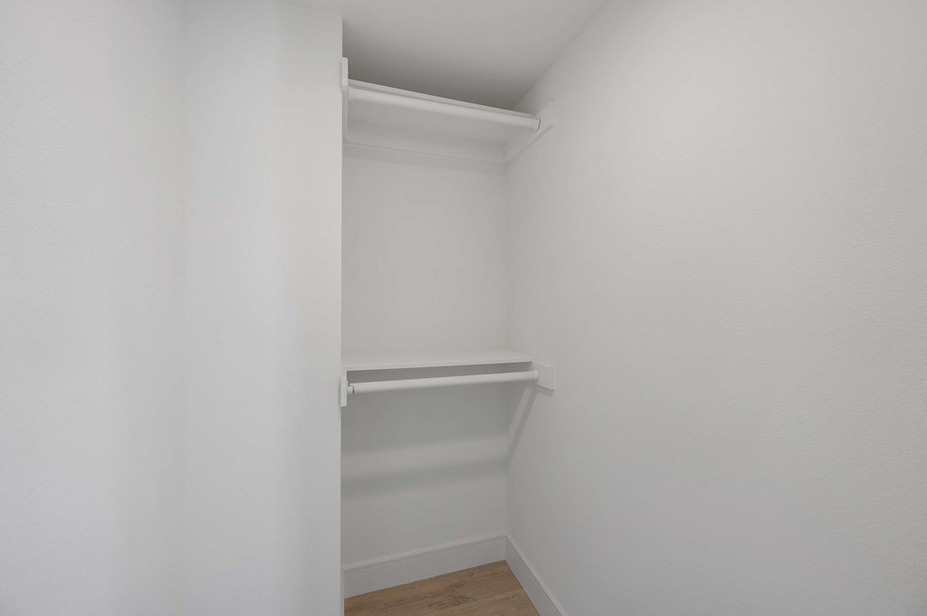 a small closet in a room with white walls and a wood floor