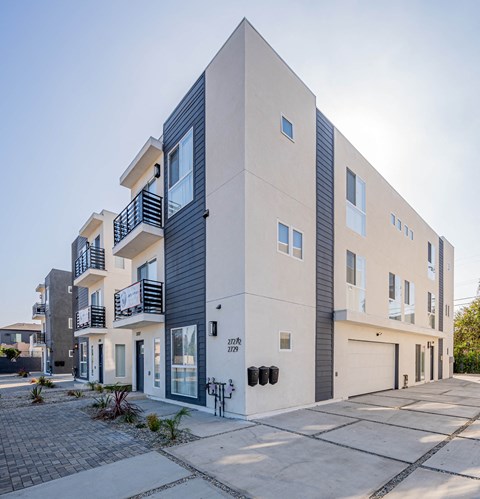 the exterior of an apartment building with a street in front of it