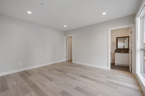 a living room with white walls and wood floors