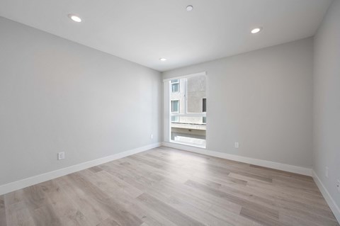 a living room with white walls and a window