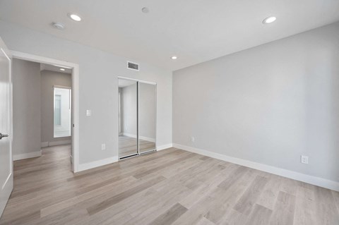 a living room with white walls and wood floors