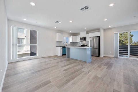 a room with a kitchen and a large window