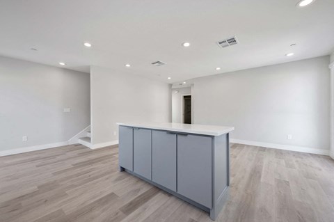 a kitchen with a island in the middle of a living room