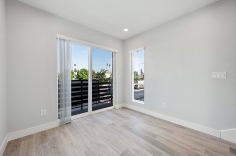 a spacious living room with sliding glass doors to a balcony