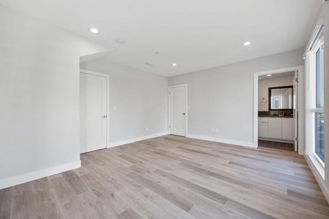 a living room with white walls and wood floors