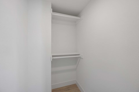 a small closet in a room with white walls and a wood floor