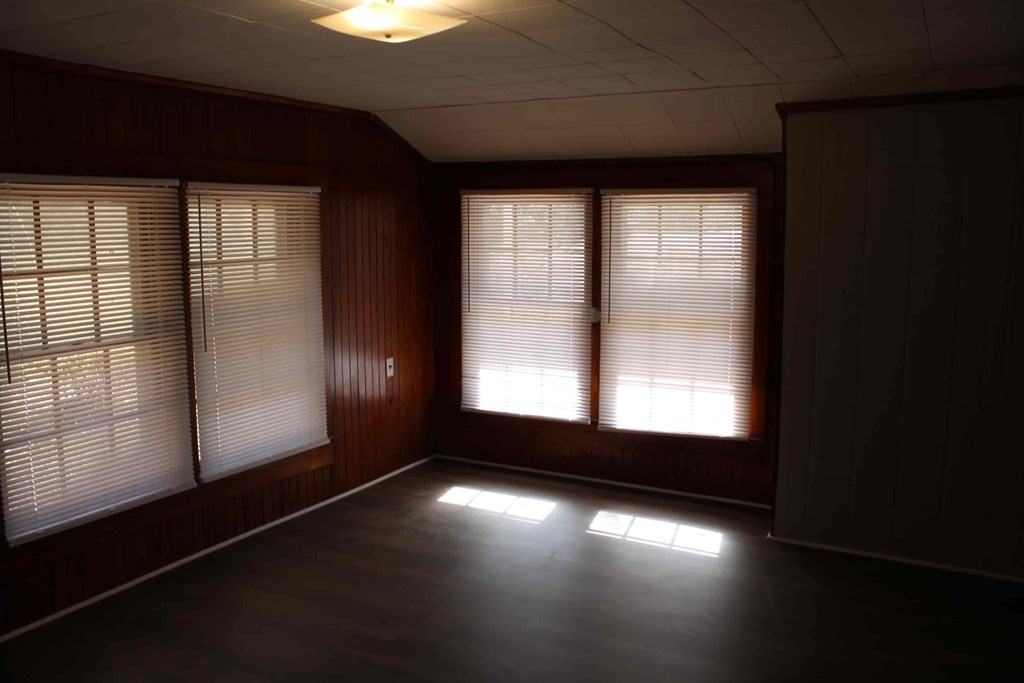 an empty living room with bay windows