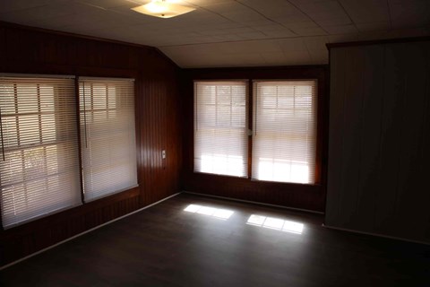 an empty living room with bay windows
