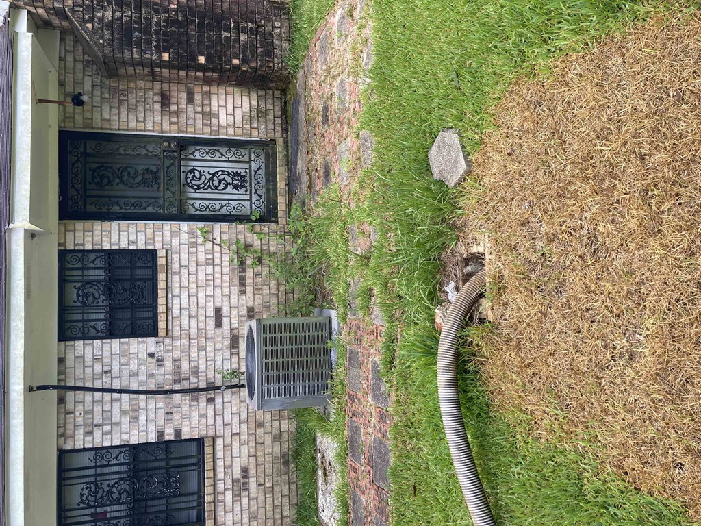an aerial view of a building with a hose in the grass