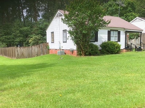 a white house with a yard and a fence