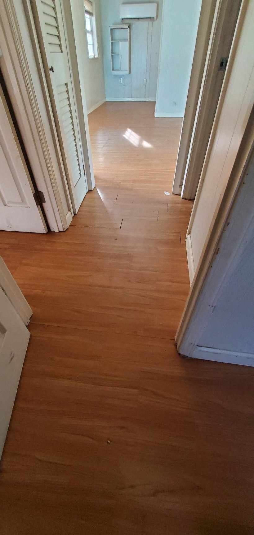 a hallway with wood floors and white doors