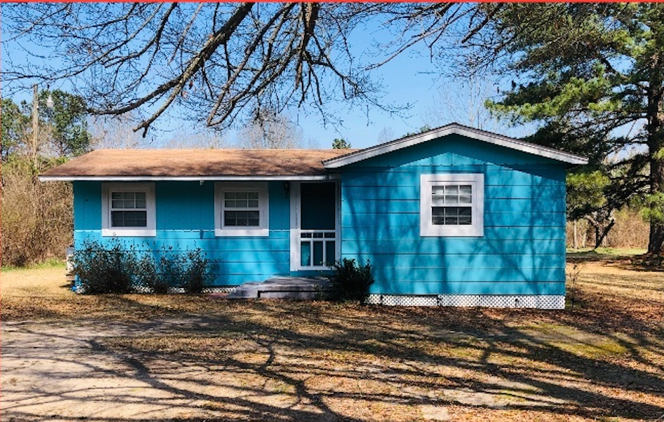 a blue house with a tree in front of it
