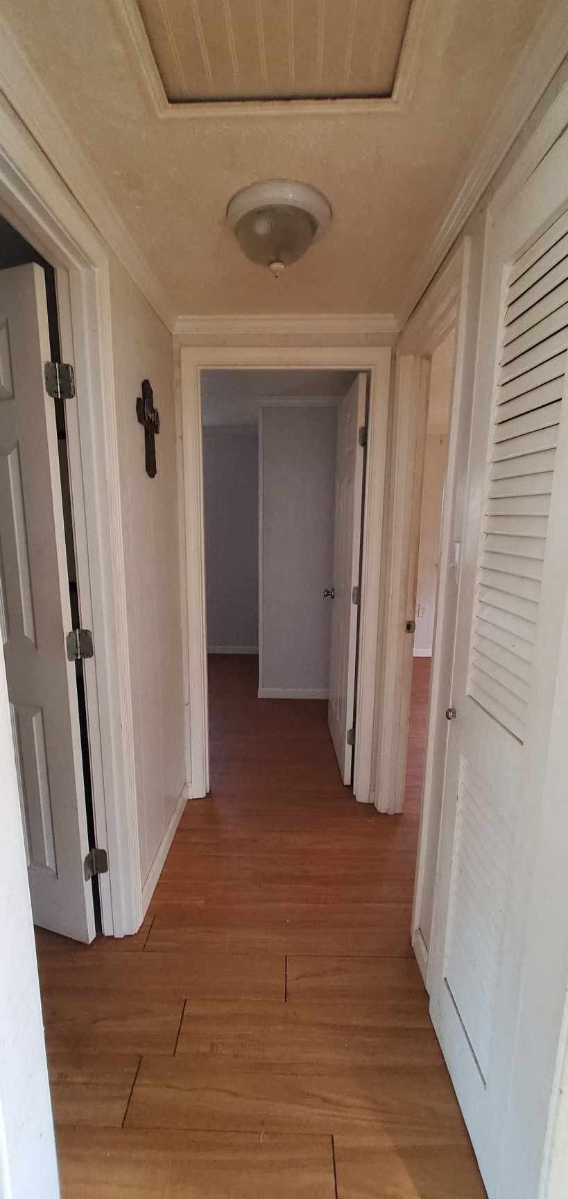 a hallway with a wood floor and white doors
