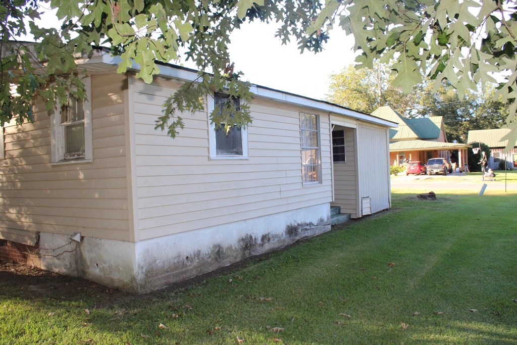 A small house with a green lawn in front.