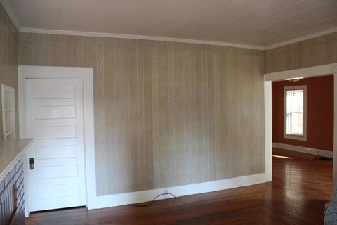 A room with a white door and wooden walls.