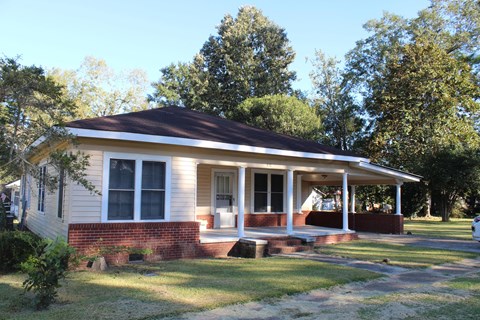 A small house with a porch and a covered front door.
