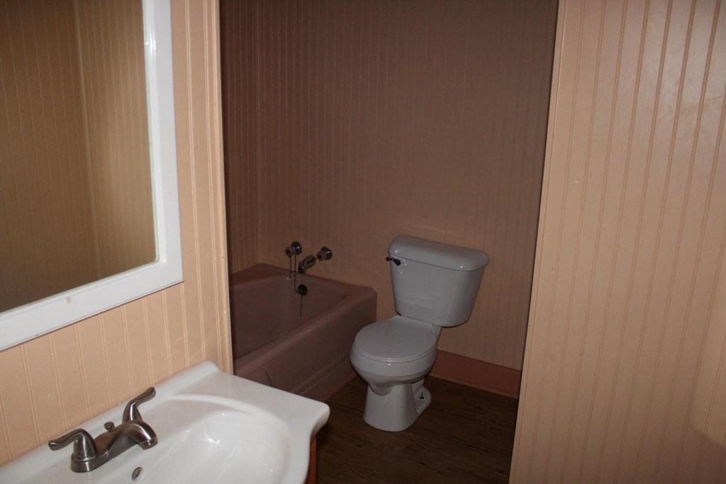 A white toilet sits next to a sink in a small bathroom.