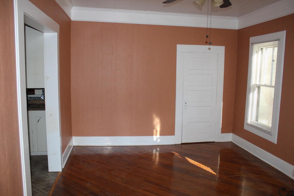 A room with a brown floor and a white door.