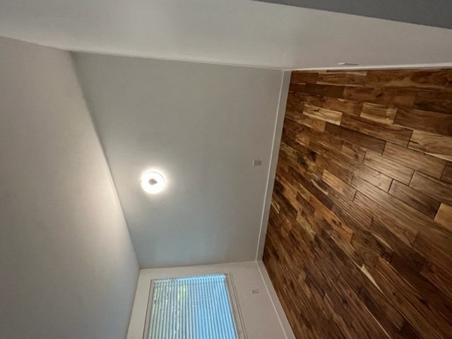 a small room with a light on the ceiling and a wooden floor