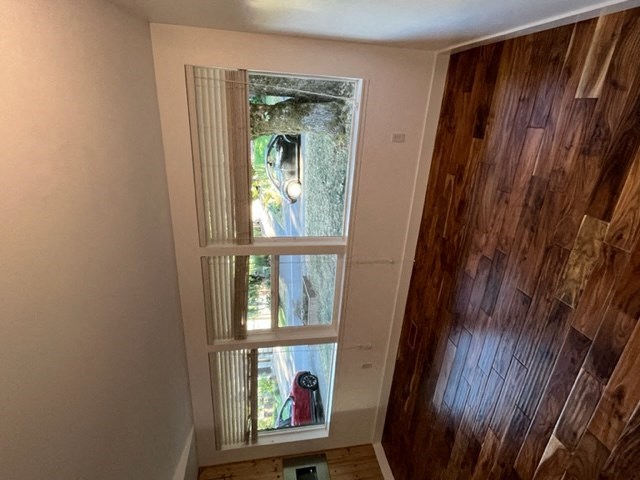 a window in a small room with a wooden floor