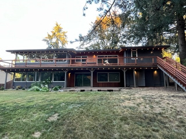 the back of a house with a yard and a deck