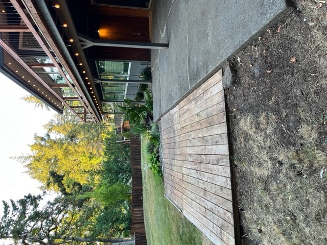 a view of the side of a building with a cliff and trees